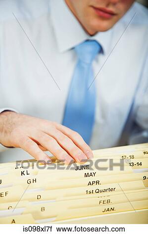 Stock Image - Office worker filing document. Fotosearch