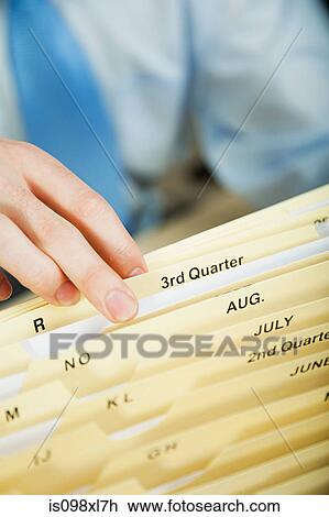 Stock Image - Office worker filing document. Fotosearch