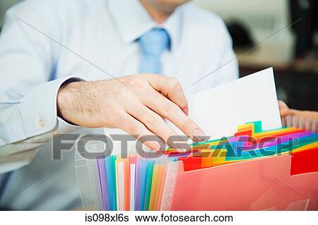 Stock Photograph - Office worker filing document. Fotosearch