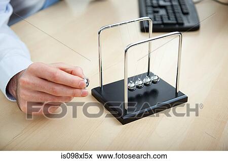 Office worker playing with newtons cradle View Large Photo Image Stock Photo - Office worker playing with newtons cradle. Fotosearch