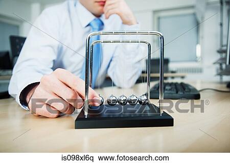 Office worker playing with newtons cradle View Large Photo Image Stock Photography - Office worker playing with newtons cradle. Fotosearch