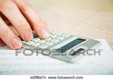 Picture - Office worker using calculator. Fotosearch