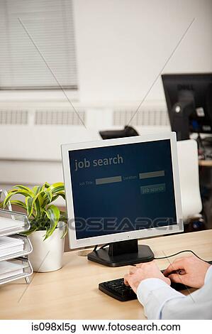 Stock Image - Office worker using computer for job search. Fotosearch