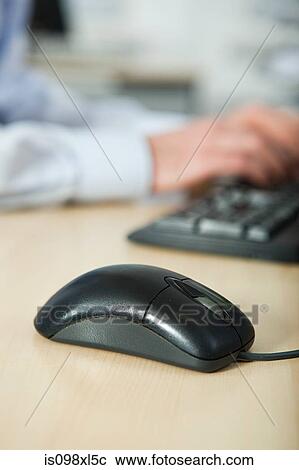 Office worker using computer, mouse in foreground View Large Photo Image Stock Image - Office worker using computer, mouse in foreground. Fotosearch