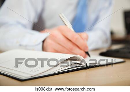 Stock Photograph - Office worker writing in diary. Fotosearch