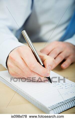 Office worker writing in notebook View Large Photo Image Stock Photo - Office worker writing in notebook. Fotosearch