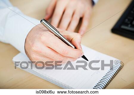 Stock Photograph - Office worker writing in notebook. Fotosearch