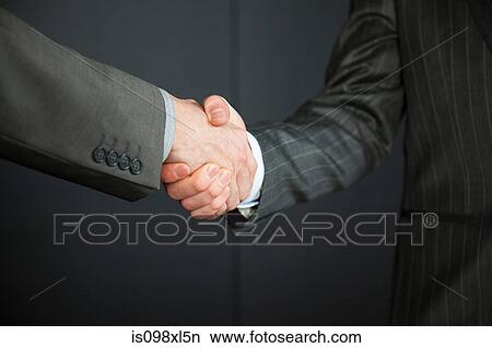 Two businessmen shaking hands View Large Photo Image Picture - Two businessmen shaking hands. Fotosearch