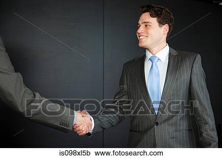 Stock Image - Two businessmen shaking hands. Fotosearch