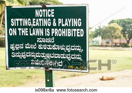 Stock Image - Prohibitive sign and sleeping dog outside a temple in Karnataka. Fotosearch