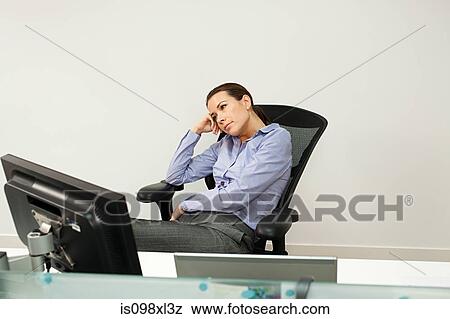 Bored businesswoman in office View Large Photo Image Stock Photo - Bored businesswoman in office. Fotosearch