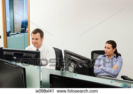 Bored businesswoman with male colleague in office View Large Photo Image Stock Image - Bored businesswoman with male colleague in office. Fotosearch