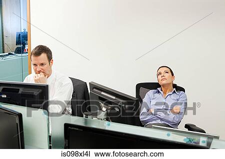 Bored businesswoman with male colleague in office View Large Photo Image Stock Image - Bored businesswoman with male colleague in office. Fotosearch
