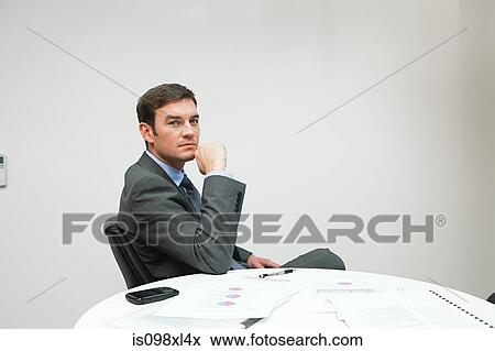 Stock Photo - Portrait of businessman at table. Fotosearch