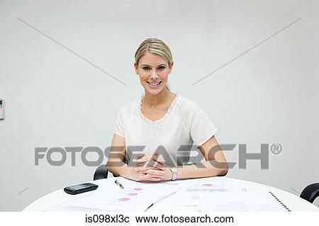 Stock Image - Portrait of businesswoman at table. Fotosearch