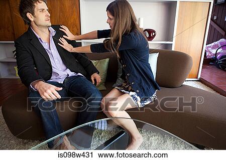 Couple sitting on sofa, woman pushing man away View Large Photo Image Stock Image - Couple sitting on sofa, woman pushing man away. Fotosearch