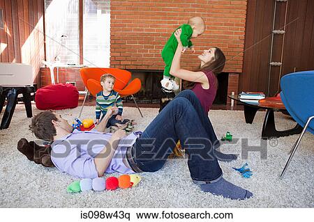 Stock Photography - Family playing in living room. Fotosearch