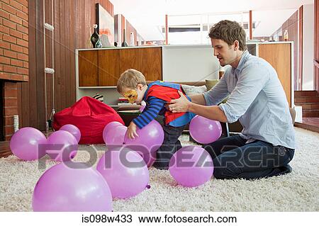 Father and son playing with balloons in living room View Large Photo Image Stock Image - Father and son playing with balloons in living room. Fotosearch