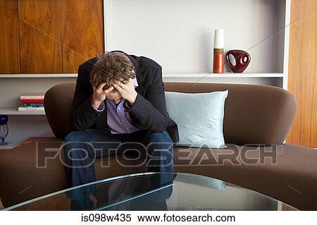 Man sitting on sofa with head in hands View Large Photo Image Stock Photography - Man sitting on sofa with head in hands. Fotosearch