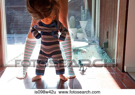 Mother helping baby son take first steps View Large Photo Image Stock Photograph - Mother helping baby son take first steps. Fotosearch