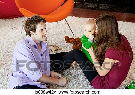 Parents with baby son in living room View Large Photo Image Stock Photo - Parents with baby son in living room. Fotosearch