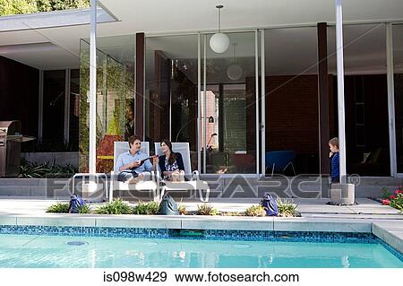 Parents with son at poolside View Large Photo Image Stock Photo - Parents with son at poolside. Fotosearch