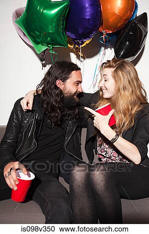 Stock Image - Couple sitting at party. Fotosearch