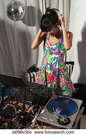 Picture - Disc jockey wearing headphones at party. Fotosearch