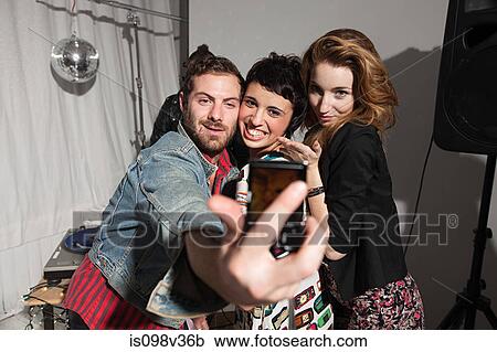 Friends photographing themselves at party View Large Photo Image Stock Image - Friends photographing themselves at party. Fotosearch
