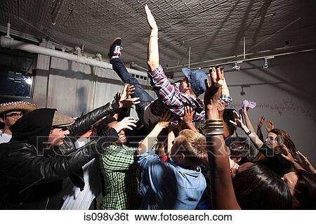Stock Photograph - Man crowd surfing at party. Fotosearch