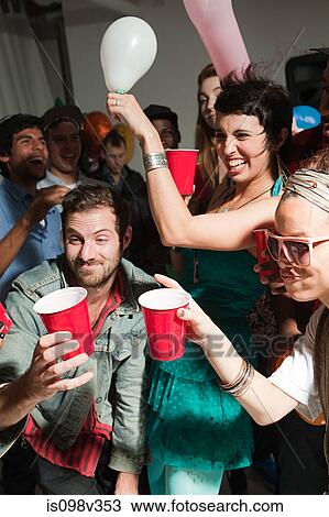 Stock Image - People dancing at party with plastic cups. Fotosearch