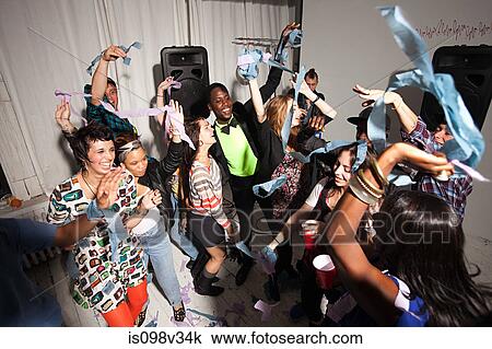 Stock Image - People dancing at party with streamers. Fotosearch