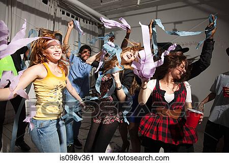 Stock Image - People dancing at party with streamers. Fotosearch