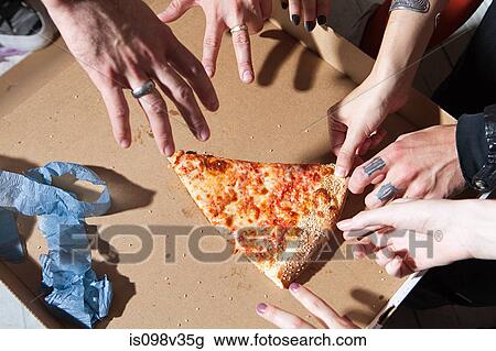 Stock Image - People taking slice of pizza at party. Fotosearch