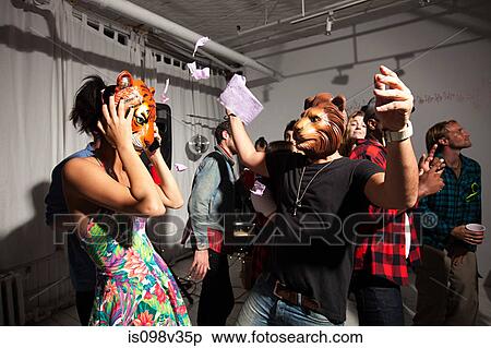 People wearing lion and tiger masks dancing at party View Large Photo Image Stock Photography - People wearing lion and tiger masks dancing at party. Fotosearch