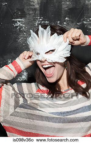 Picture - Woman wearing mask at party. Fotosearch