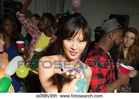 Stock Image - Woman with glitter in her palm at party. Fotosearch