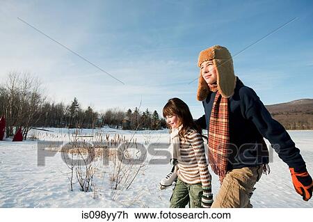 Stock Image - Brother and sister walking in snow. Fotosearch