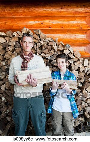 Father and son holding logs, portrait View Large Photo Image Stock Image - Father and son holding logs, portrait. Fotosearch
