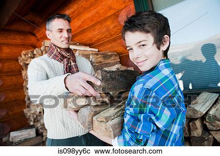 Stock Image - Father and son holding logs. Fotosearch