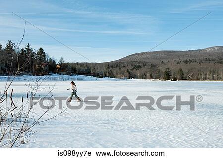 Girl walking in snow with ice skates View Large Photo Image Stock Image - Girl walking in snow with ice skates. Fotosearch