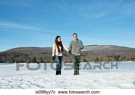 Stock Image - Mid adult couple holding hands. Fotosearch