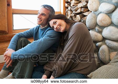 Mid adult couple sitting in log cabin View Large Photo Image Picture - Mid adult couple sitting in log cabin. Fotosearch