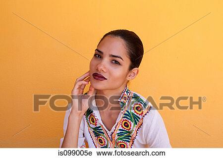 Stock Image - Woman against yellow wall. Fotosearch
