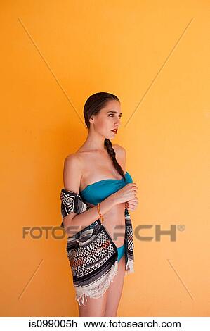 Stock Image - Woman against yellow wall. Fotosearch