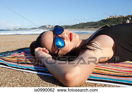 Woman lying on beach towel View Large Photo Image Stock Image - Woman lying on beach towel. Fotosearch