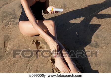 Woman on beach applying suncream View Large Photo Image Stock Photo - Woman on beach applying suncream. Fotosearch