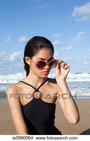 Woman on beach wearing sunglasses View Large Photo Image Picture - Woman on beach wearing sunglasses. Fotosearch