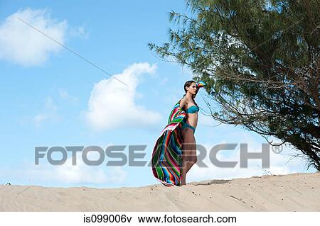Woman standing on sand dune View Large Photo Image Stock Photo - Woman standing on sand dune. Fotosearch
