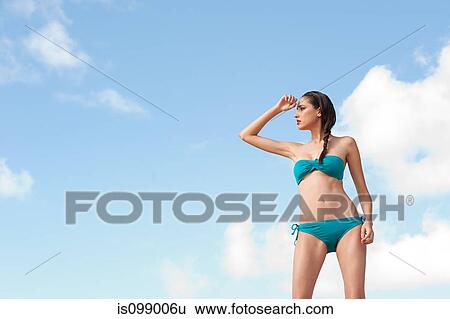 Woman wearing bikini shielding eyes View Large Photo Image Stock Photograph - Woman wearing bikini shielding eyes. Fotosearch